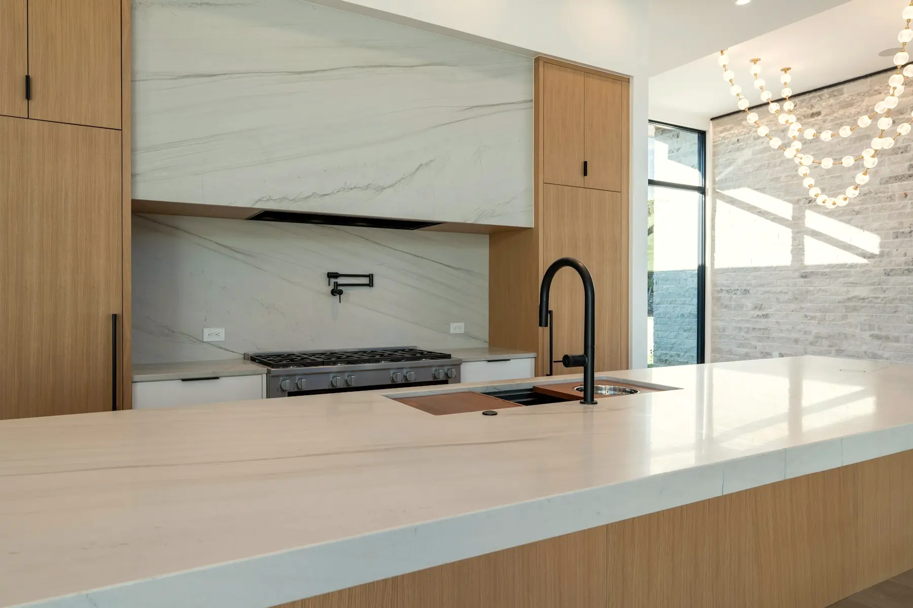 Book-matched marble meeting white oak cabinetry in the kitchen.