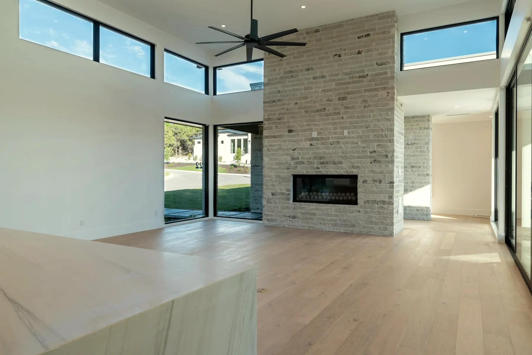 The great room with its limestone chimney wall and clerestory windows above.